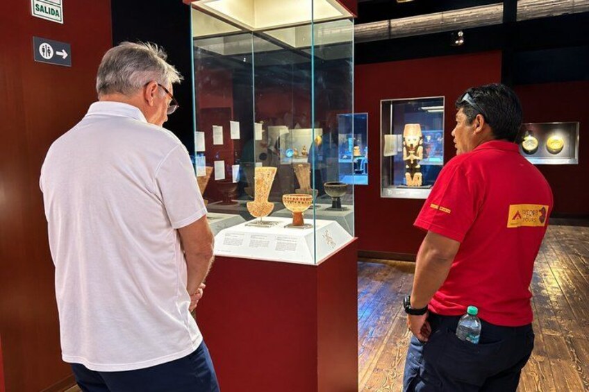 Two people examining artifacts in a museum exhibit. 4
