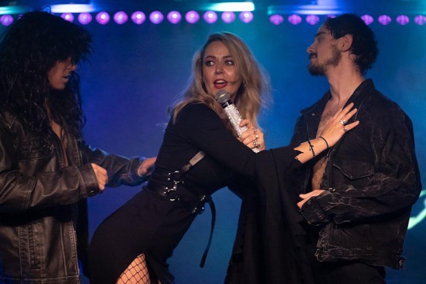 A stage with three people, one holding a microphone. 5