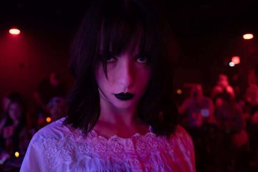 A person in a dimly lit room with red ambient lighting. 5