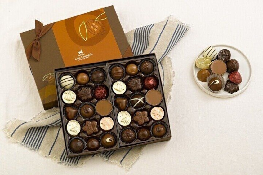 A box of assorted chocolates and a plate with some of them. 4