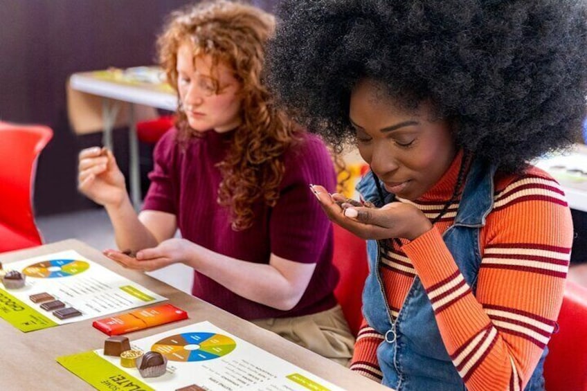 Two individuals at a table with documents and a pie chart. 1