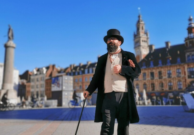 A man in a long coat and top hat walking with a cane in a historic square with buildings and a tower in the background. 1