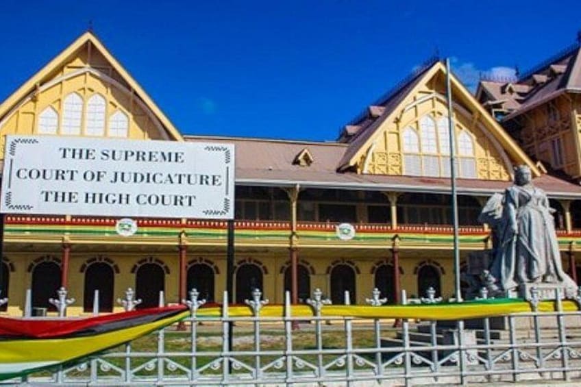 A historic building with a sign reading 'The Supreme Court of Judicature The High Court.' 3