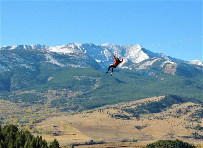 A person bungee jumping with a mountainous landscape in the background. 1