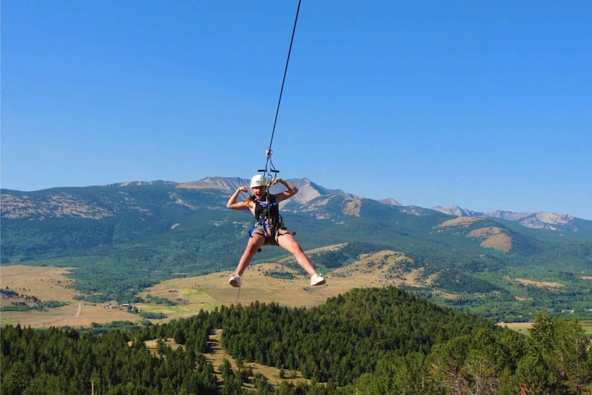 A person ziplining over a mountainous landscape. 5