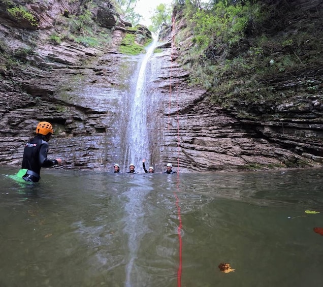 A group of people in a canyon with a waterfall. 4