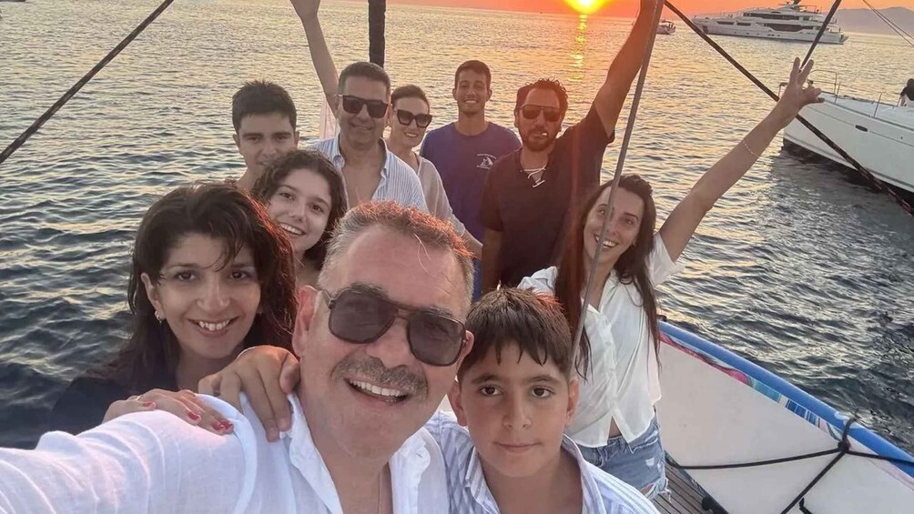 A group of people on a boat with the sun setting in the background. 3