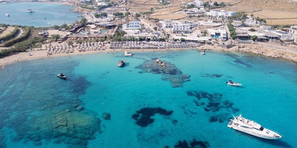 A coastal town with clear turquoise waters, boats, and a yacht. 4