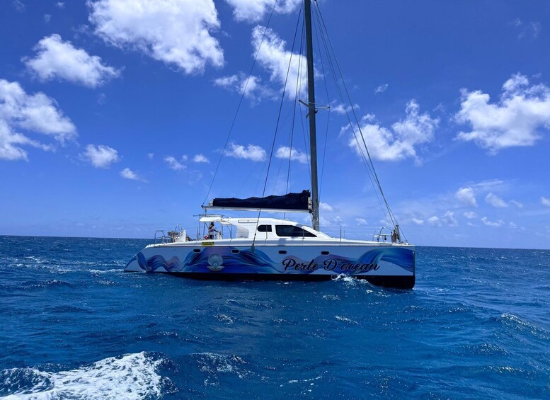 A sailboat named 'Perle D'océan' on the ocean. 4