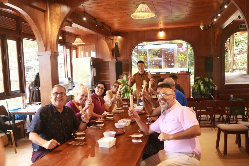 A group of people sitting around a wooden table in a restaurant with a rustic interior. 3