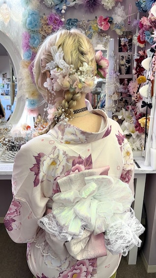 A person with a floral hair accessory and a floral-patterned garment in a shop with various items on display. 3