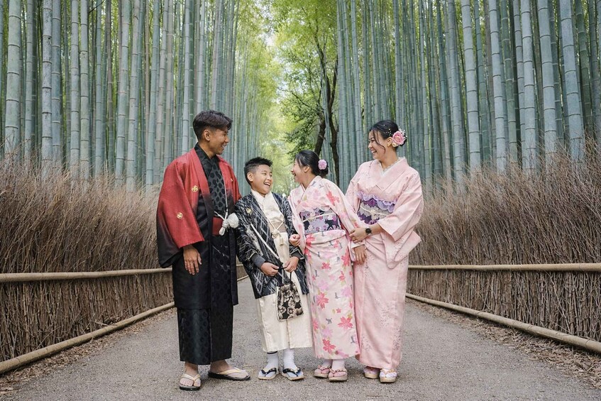 A group of people in traditional attire standing on a path surrounded by bamboo. 4