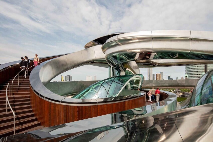 A modern architectural structure with a glass elevator and wooden stairs. 3