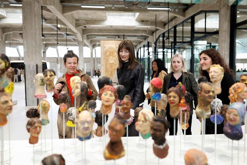 A group of people observing artistic sculptures in a modern indoor space. 5
