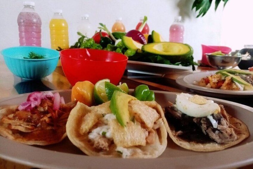 A plate with three tacos, a bowl of salad, and a plate of rice. 2