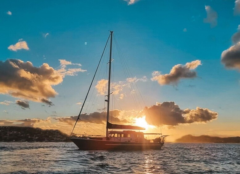 A sailboat on calm waters with the sun setting in the background. 3