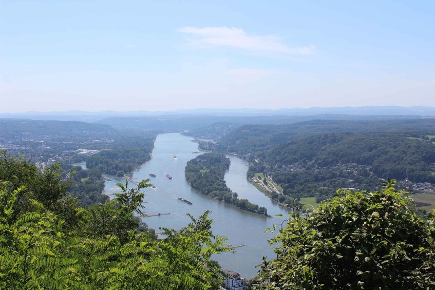 A river winding through a valley with dense forests on either side and a distant cityscape. 2