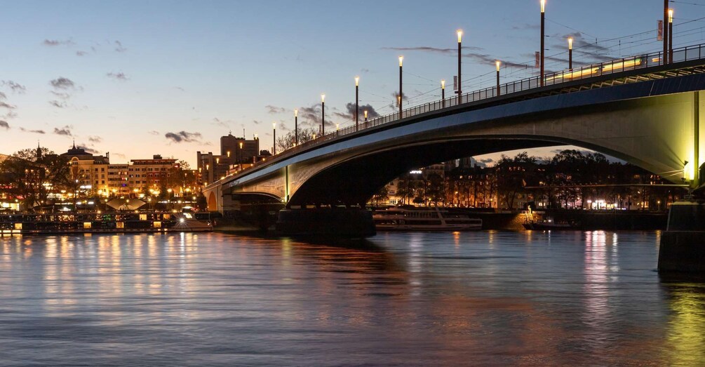 A bridge over a river with city lights reflecting on the water. 4