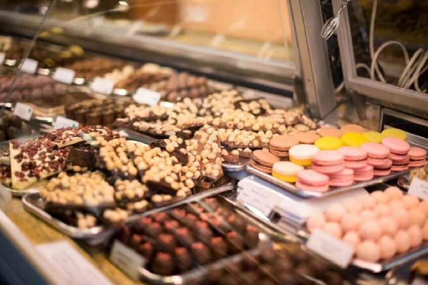 An assortment of chocolates and macarons in a display case. 3
