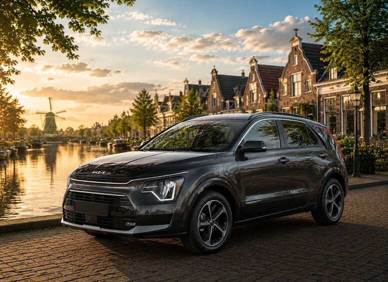 A dark-colored SUV parked on a cobblestone street with a canal and traditional buildings in the background. 4