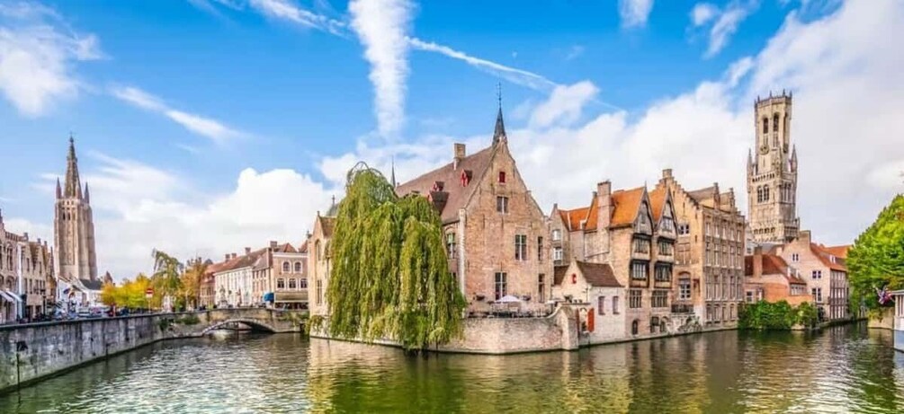 A historic European town with a river, a bridge, and a prominent church tower. 1