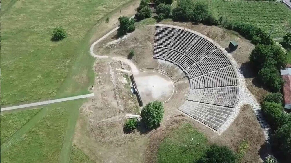 An amphitheater with a semi-circular arrangement of seating and a central stage area. 1