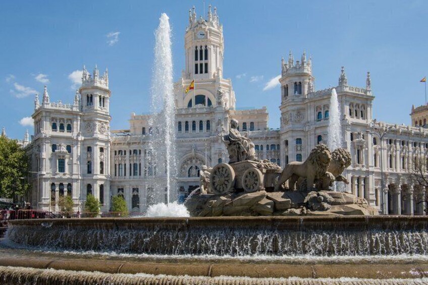 A grand palace with a central fountain and statues. 1