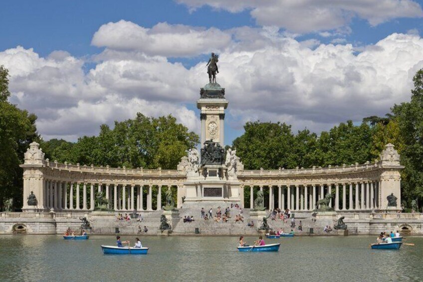 A classical building with a central statue, surrounded by water and people in boats. 3