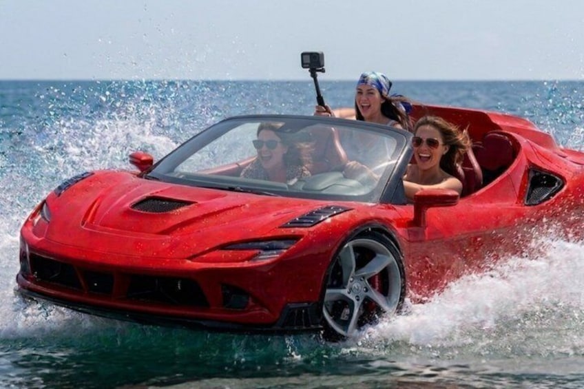 A red sports car driving through water. 2
