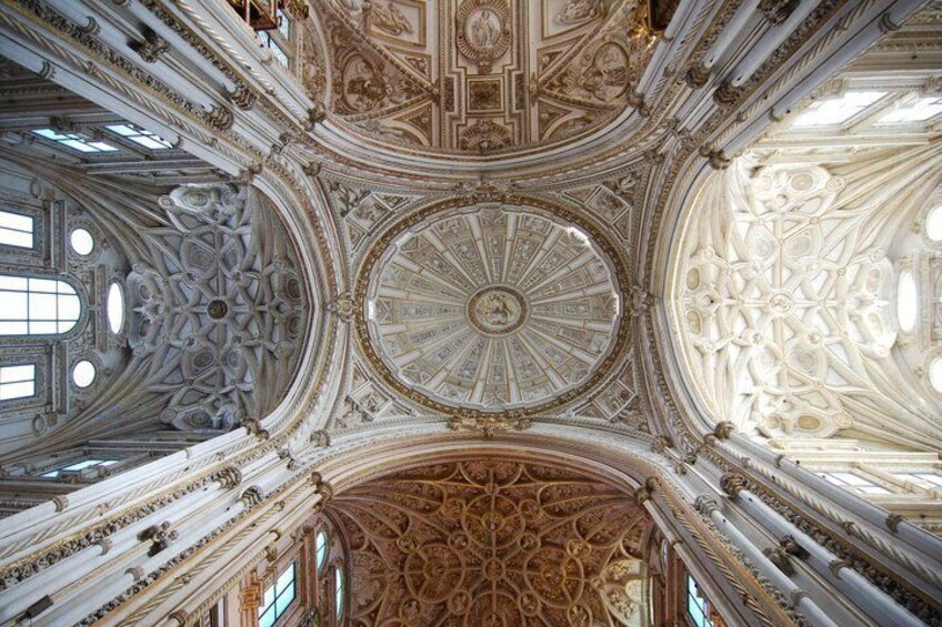 An ornate ceiling with intricate patterns and a central circular design. 1