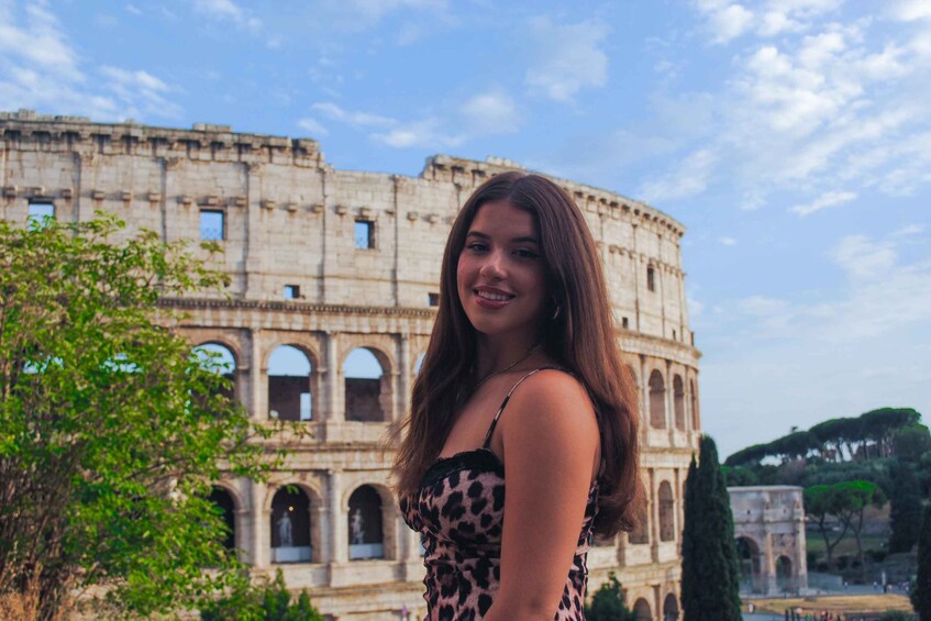 A person in front of the Colosseum with trees and a clear sky. 3