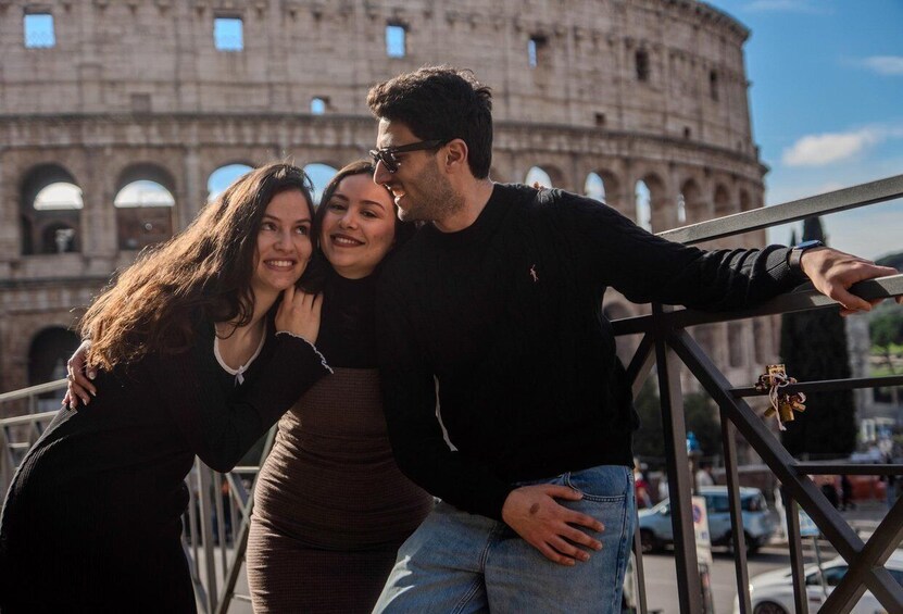 A person leaning on a railing with the Colosseum in the background. 4
