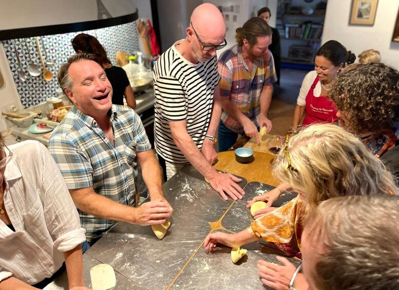 A group of people engaged in a cooking activity, with a focus on dough preparation. 3