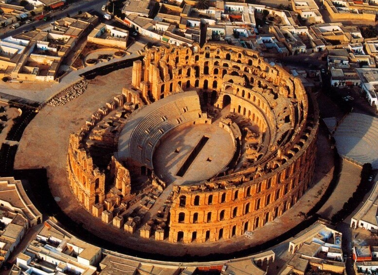 The Colosseum in Rome surrounded by city buildings. 1
