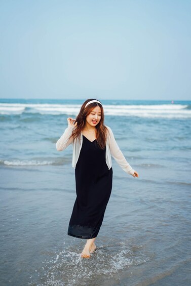 A person walking on a beach with waves in the background. 2