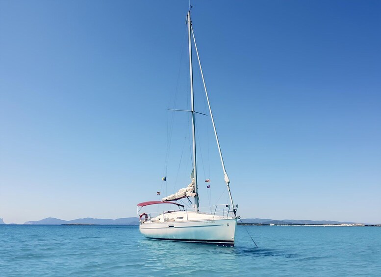 A sailboat on calm waters with a clear sky. 1
