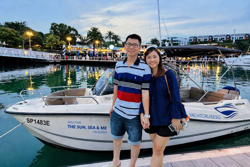 A couple standing on a dock with a yacht named SP1483E. 2