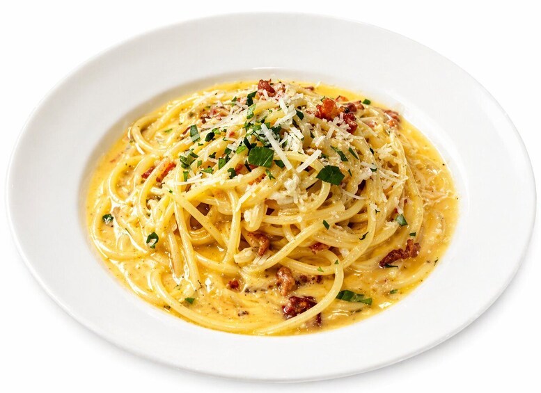 A plate of spaghetti with a creamy sauce, topped with grated cheese and herbs. 4