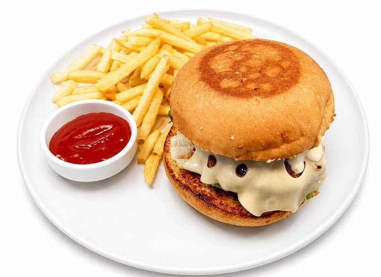 A burger with cheese and a side of fries on a white plate. 3