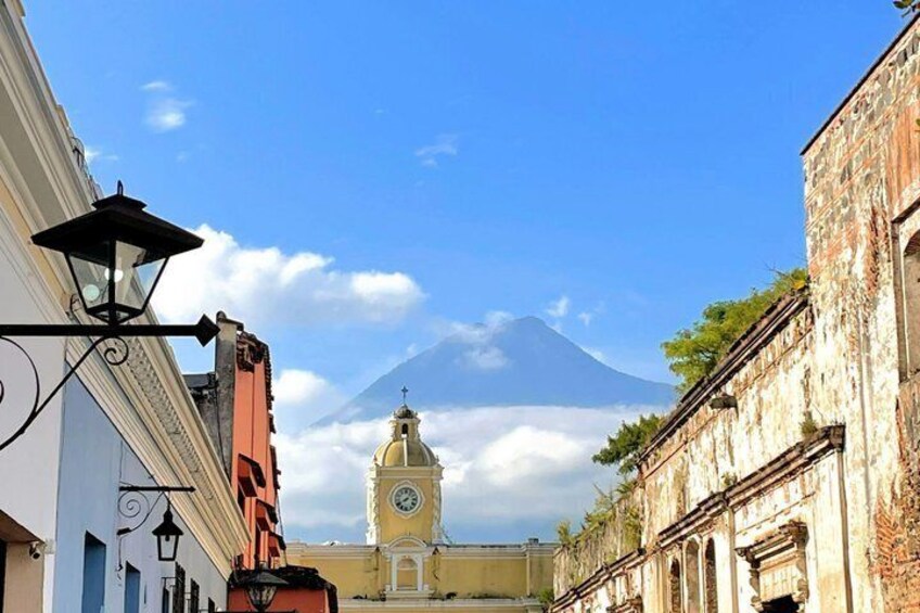 A street with buildings, a clock tower, and a mountain in the background. 5