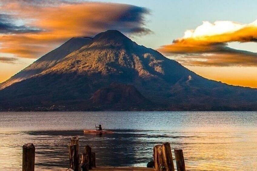 A mountain, a body of water, and a person in a boat. 1