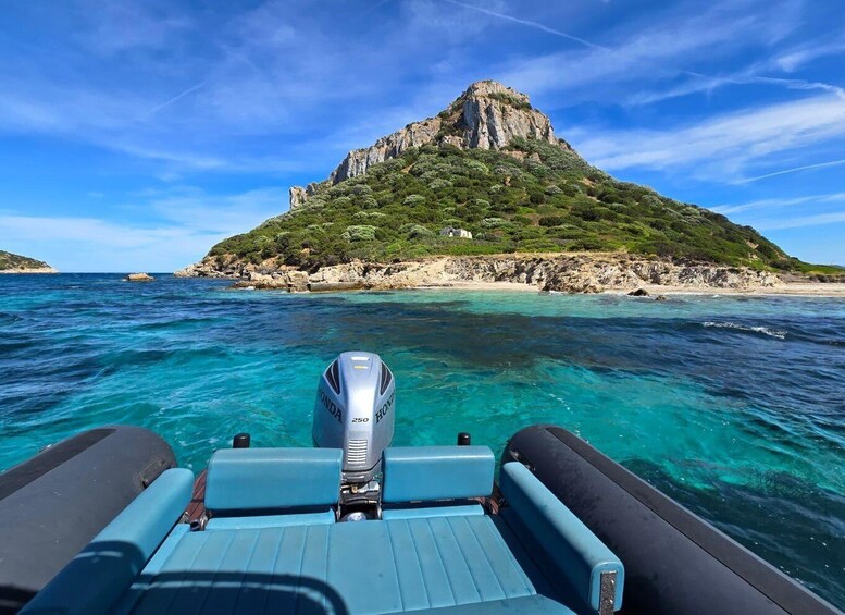 A boat with a Honda 250 outboard motor heading towards a rocky island with lush greenery. 4