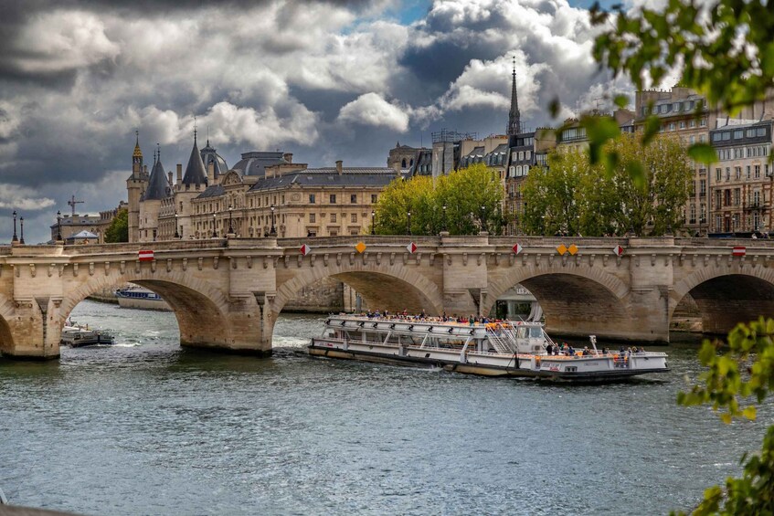 A stone bridge over a river with a boat carrying passengers. 2