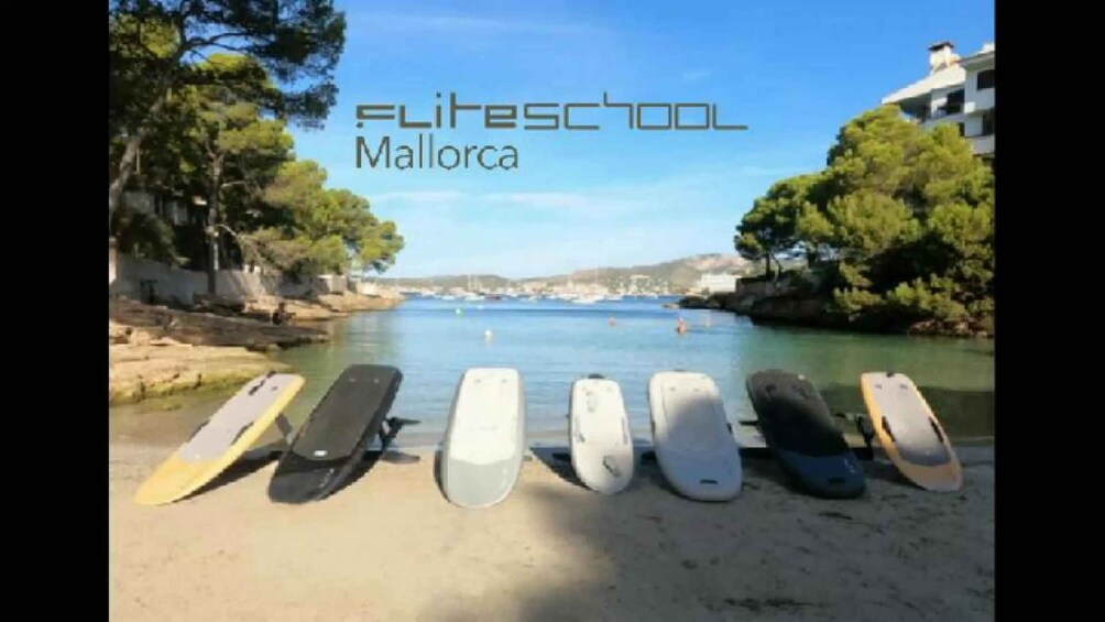 A beach with surfboards lined up and the text 'FLITESCHOOL Mallorca'. 1
