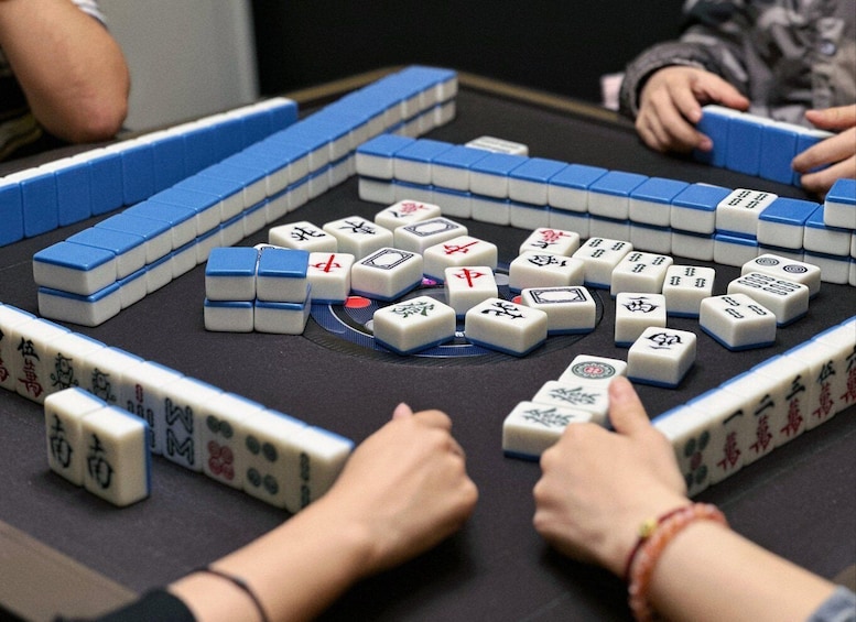 A game of Mahjong with tiles arranged on a table. 2