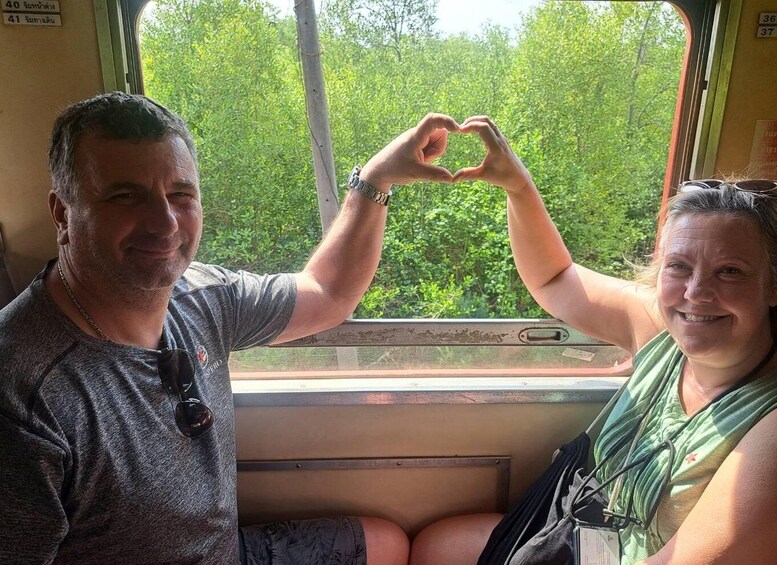 Two people making a heart shape with their hands inside a vehicle. 2