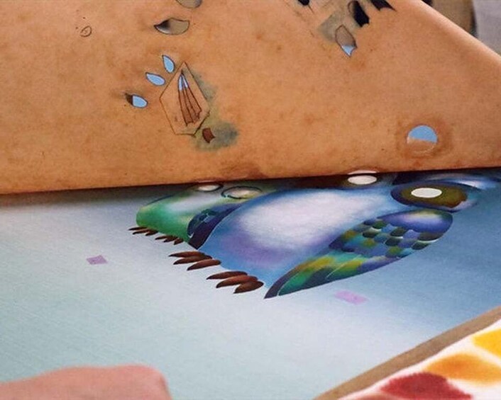A colorful bird illustration on a textured surface. 1