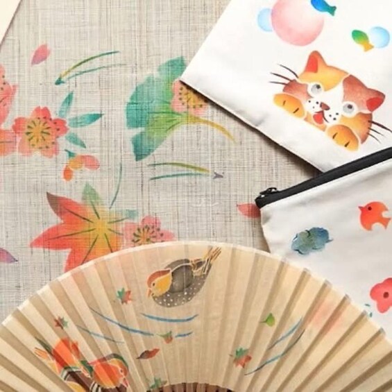 A fan with bird illustrations, a fabric with floral patterns, and a bag with a cat design. 3