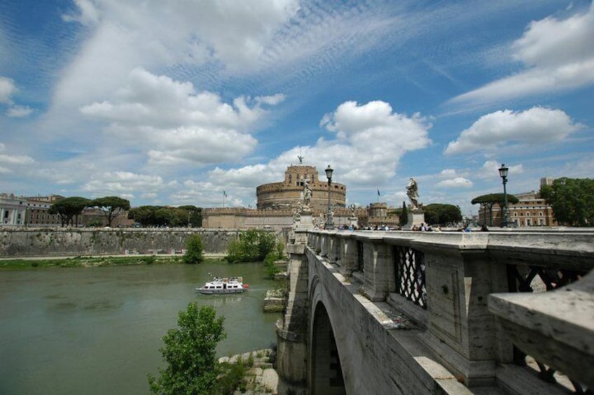 A river with a bridge, a boat, and a historic building in the background. 1