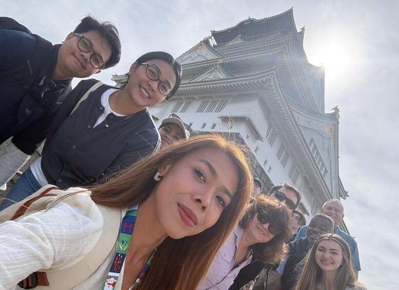 A group of people in front of a traditional building with ornate architecture. 2